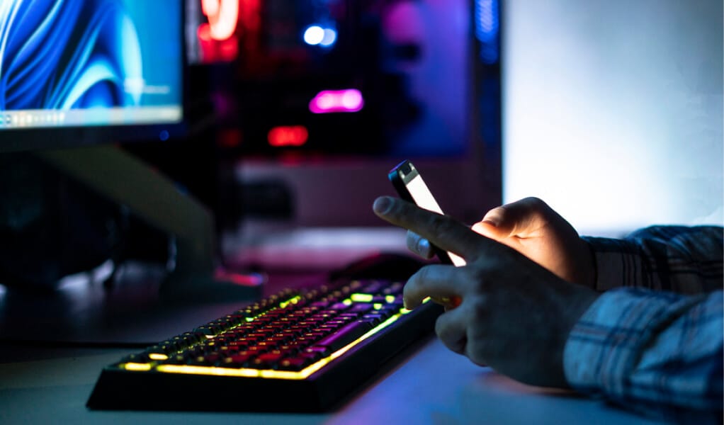 Servicio SEO en Panamá - Persona utilizando un teléfono móvil y computadora para optimizar el rendimiento web