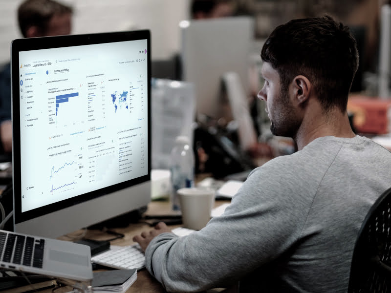 Persona trabajando frente a un monitor con un panel de análisis de datos